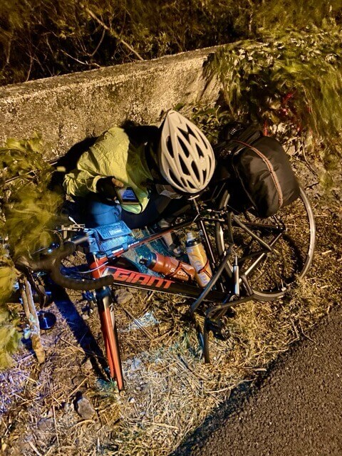 黑夜中一個騎士在路邊維修單車