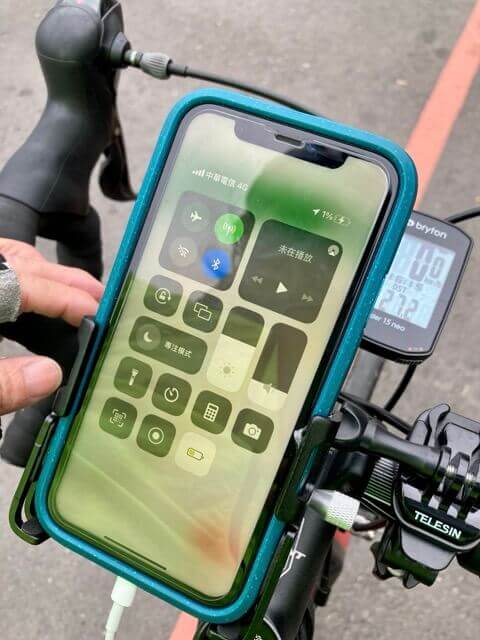 藍色手機殼的手機，裝在單車的手機架上連接充電線